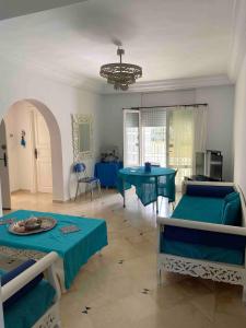a living room with two beds and a table at Modern 3-Bedroom Apartment in Gated Residence with Pool in Yasmine +27 photos