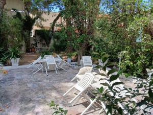 a group of white chairs sitting in a yard at Pension Alkistis in Tolo