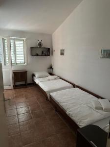 two beds in a room with white walls at Iskra house - Perazica Do in Perazića Do