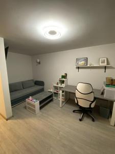 una habitación con un sofá, un escritorio y una silla en MANIU-APUSULUI Studio, en Bucarest