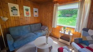 a living room with a blue couch and a window at gemütliches TinyHouse im Naturpark in Rorodt