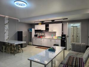 a living room with a table and a kitchen at Town Yard Hostel in Ulaanbaatar