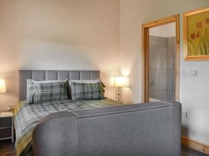 a bedroom with a large bed and a shower at Uk46833 - Low Hollas Farmhouse in Threlkeld