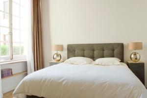 ボーヌにあるミレジム 78のベッドルーム(白い大型ベッド、ランプ2つ付)