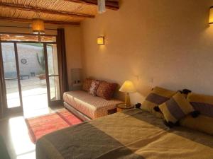 a bedroom with a bed and a couch and a window at Dar Tikida - Luxury Beach Villa - 8 people in Sidi Kaouki +67 photos