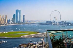 Blick auf eine Stadt mit einem Riesenrad im Hintergrund in der Unterkunft Luxury 2 Bedroom Apartment - Private Beach - Emaar Beach Vista in Dubai