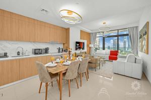 eine Küche und ein Wohnzimmer mit Tisch und Stühlen in der Unterkunft Luxury 2 Bedroom Apartment - Private Beach - Emaar Beach Vista in Dubai