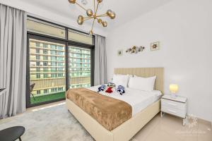 ein Schlafzimmer mit einem Bett und einem großen Fenster in der Unterkunft Luxury 2 Bedroom Apartment - Private Beach - Emaar Beach Vista in Dubai
