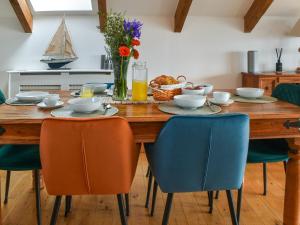 a dining room table with chairs and a boat on it at Bayview Cottage in Penzance