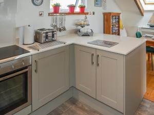 a kitchen with white cabinets and a counter top at Bayview Cottage in Penzance