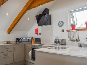 a kitchen with white cabinets and a counter top at Bayview Cottage in Penzance