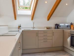 a kitchen with white cabinets and a window at Bayview Cottage in Penzance +13 photos