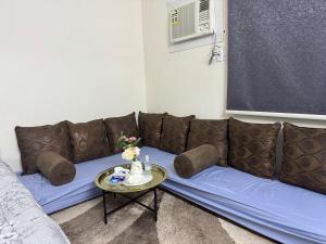 a brown couch sitting in a living room with a table at Airport neighborhood Studio in Hail