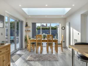 a kitchen and dining room with a wooden table and chairs at Garden View in Bournemouth