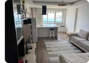 Una sala de estar con un sofá y una cocina. en Brecani Apartment, en Shëngjin