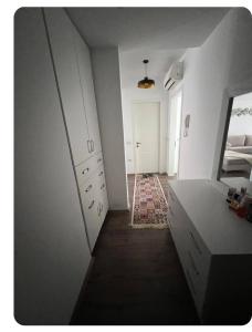 Habitación blanca con tocador y espejo en Brecani Apartment, en Shëngjin