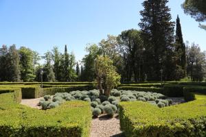 a garden with a bunch of bushes and trees at Hotel La Collegiata - Adults Only in San Gimignano