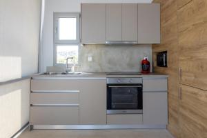 a kitchen with white cabinets and a sink at Ambi Homes 2 in Karfas
