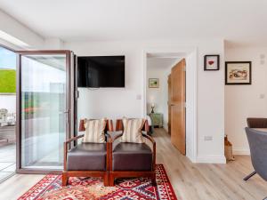 a living room with a chair and a tv at Uk46790 - Orchard Retreat in Woolaston