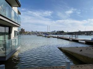 a body of water with a building and a dock at Riverside Townhouse with Private Garden in London