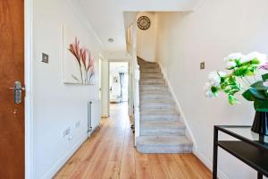 a staircase in a house with a vase of flowers at Riverside Townhouse with Private Garden in London
