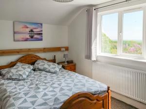a bedroom with a bed and two windows at Elder Cottage in Bridgend +11 photos