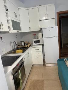 une cuisine avec des armoires blanches, un évier et un réfrigérateur dans l'établissement Apartament In Lalzi Bay, Lura 1 Complex, à Draç 6 autres photos