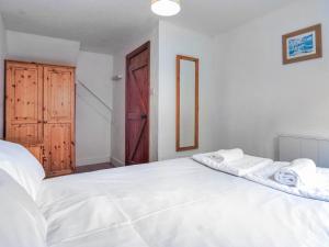 ein Schlafzimmer mit einem weißen Bett mit Handtüchern darauf in der Unterkunft Crackington Cottage in Bude
