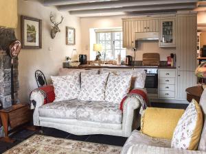 a living room with a couch and a kitchen at Summerhill Tanyrhos in Blaenau-Ffestiniog