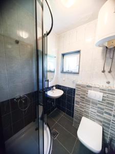 ein Badezimmer mit Dusche, Waschbecken und Toilette in der Unterkunft Apartments and Rooms Marica in Makarska