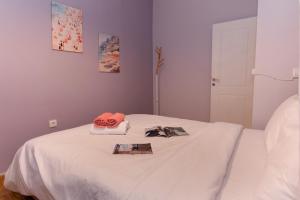 a white bed with two hats and a book on it at Prime location - 2 bd Boutique apartment in Thessaloniki