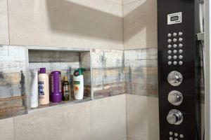 a shelf in the corner of a shower with bottles at Cherry Chirp Cottage in County Fermanagha in Garrison +25 photos