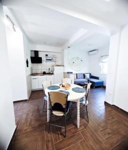 eine Küche und ein Wohnzimmer mit Tisch und Stühlen in der Unterkunft Apartments and Rooms Marica in Makarska