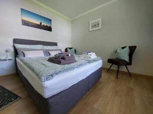 a bedroom with a bed and a chair in it at Ferienwohnung Breitschuhs Havenwelten Bremerhaven in Bremerhaven