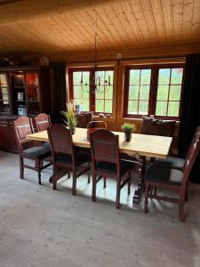 a dining room with a wooden table and chairs at Spacious mountain cabin in Valdres with 3 bedrooms in Vevle +9 photos
