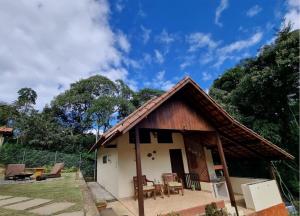 a small house with a wooden roof at Chalé Fazendinha in Bocaina de Minas