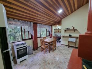 a kitchen with a stove and a table in a room at Chalé Fazendinha in Bocaina de Minas