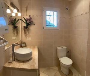 a bathroom with a toilet and a sink and a window at Maison récente entre mer et montagne in Figari +9 photos
