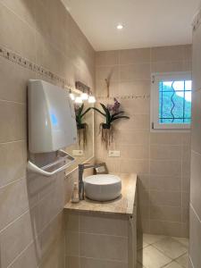 a bathroom with a white sink and a window at Maison récente entre mer et montagne in Figari