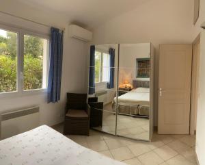 a bedroom with a mirror and a bed and a window at Maison récente entre mer et montagne in Figari