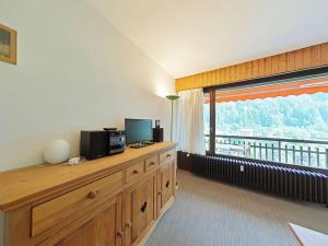 a living room with a television and a large window at Appartement au centre - 3 pièces, 6 personnes, ascenseur - FR-1-241-222 in Le Grand-Bornand