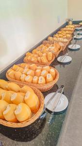 a row of baskets of food on a table at Areia do Atlantico Hotel in Porto Seguro