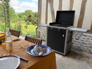un pollo seduto su un piatto su un tavolo con una griglia di Charming house surrounded by nature a Courtonne-la-Meurdrac