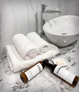 a bottle of wine sitting on a bathroom counter with towels at Hotel 24st Prestige in Seosan