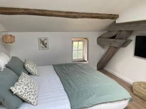 a bedroom with a large bed and a window at La Sénéchalerie - Chambres d'hôtes in Chasselay