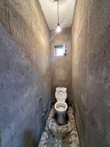 a small bathroom with a toilet in a wall at Quba Dağ Mənzərəli Bağ Evi Quba Mountain View Garden House in Küsnǝt +11 photos