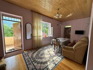 a living room with a couch and a table at Quba Dağ Mənzərəli Bağ Evi Quba Mountain View Garden House in Küsnǝt