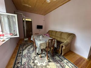 a living room with a table and a couch at Quba Dağ Mənzərəli Bağ Evi Quba Mountain View Garden House in Küsnǝt