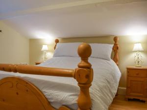 ein Schlafzimmer mit einem Bett mit weißer Bettwäsche und zwei Lampen in der Unterkunft Well Cottage in Welton