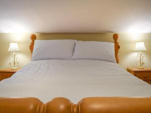 ein Schlafzimmer mit einem Bett mit zwei Lampen an Tischen in der Unterkunft Well Cottage in Welton + 5 Fotos